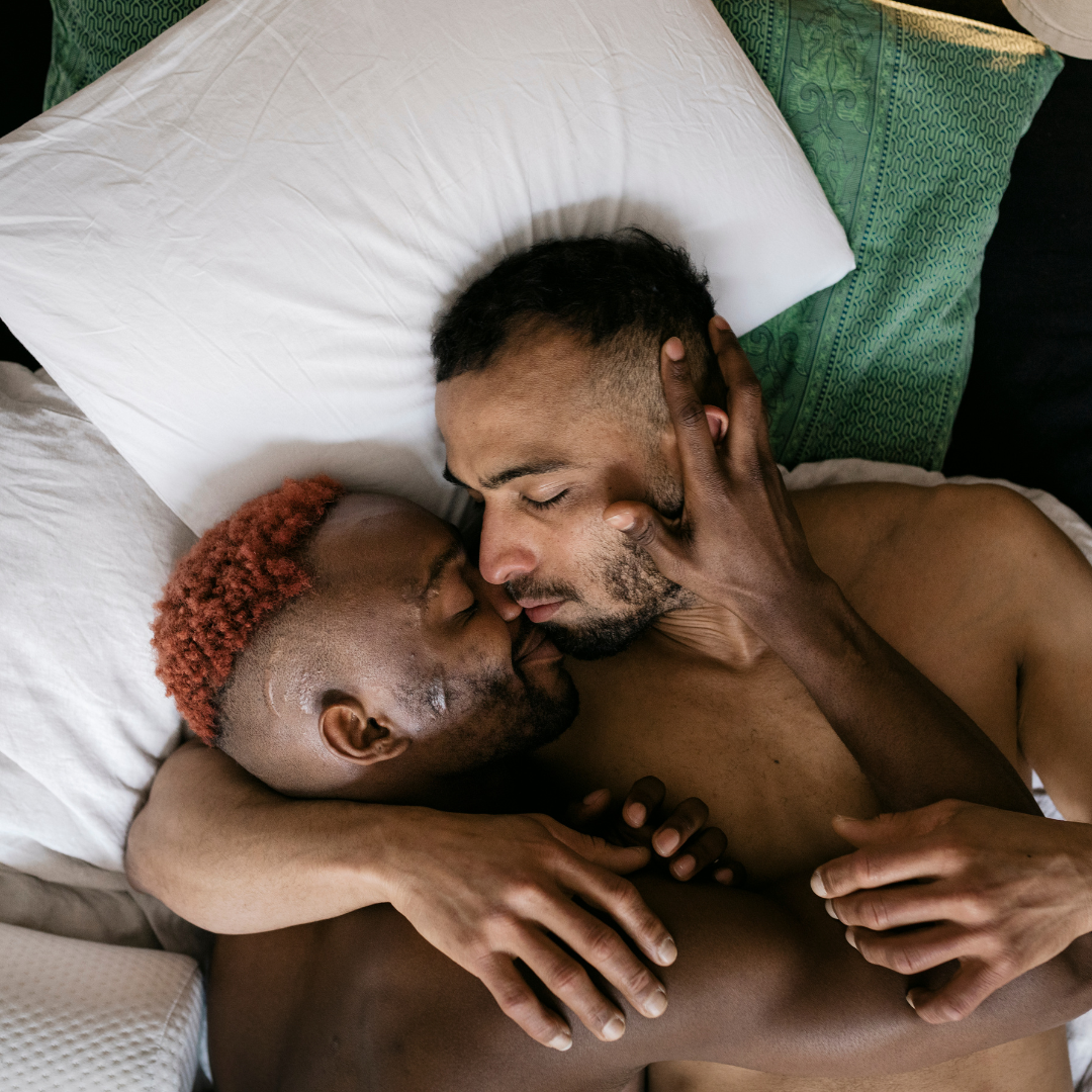 wo men, presumably ex-partners, sharing an intimate moment in bed. They're in deep conversation, suggesting they're navigating the complexities of their past relationship.