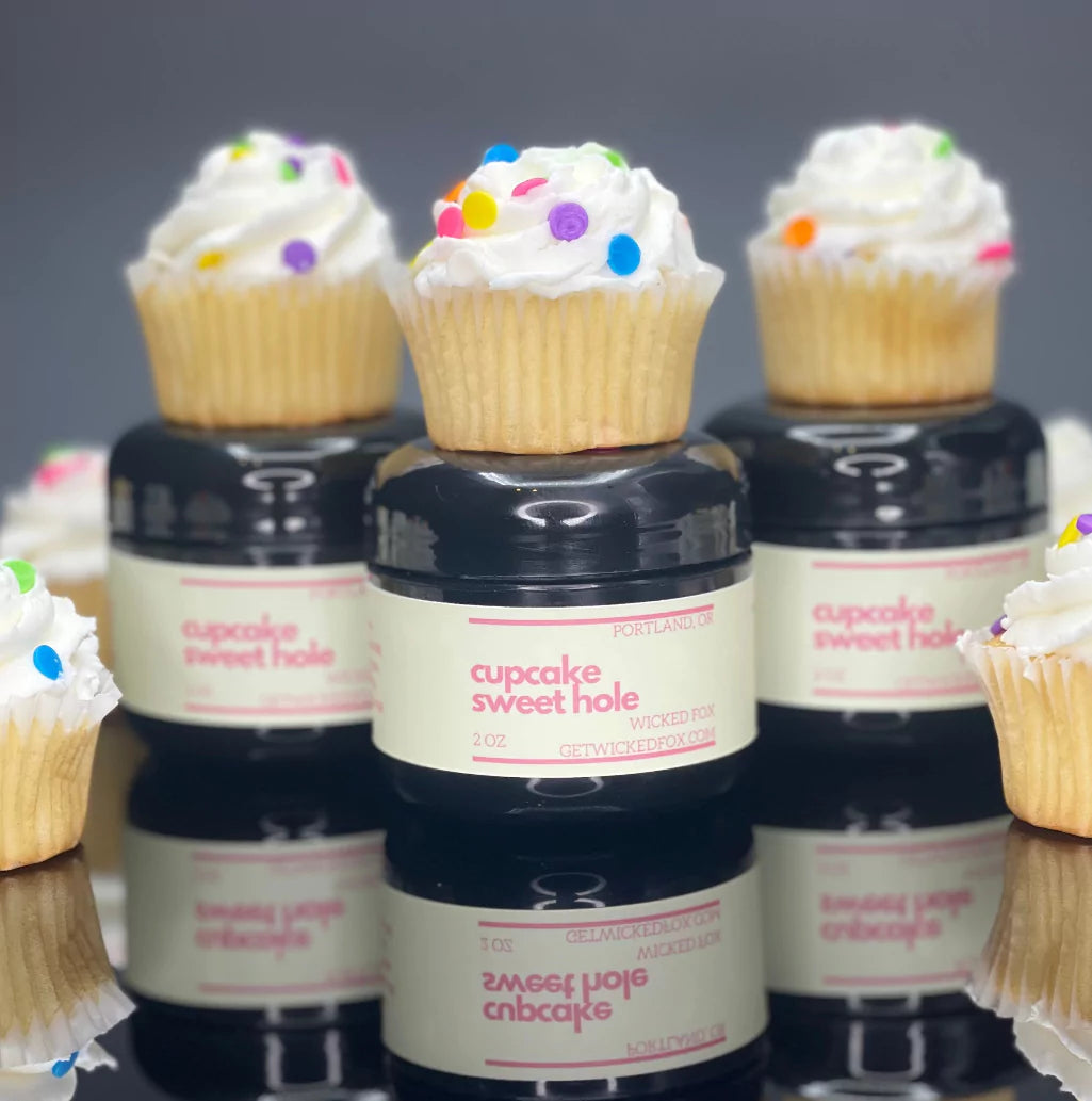 Three jars of cupcake sweet hole with cupcakes all around them are proudly standing there. this product by wicked fox is a great option for gay prides and circuit parties to flavor yourself up being dancing the night away. 