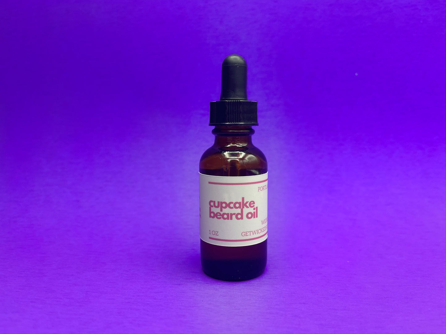 A bottle of Wicked Fox's Cupcake Beard Oil, enriched with natural ingredients, designed for the grooming needs of queer and trans men. Perfect for softening facial hair and reducing skin blemishes. Ideal beard care product for gay men shopping online.