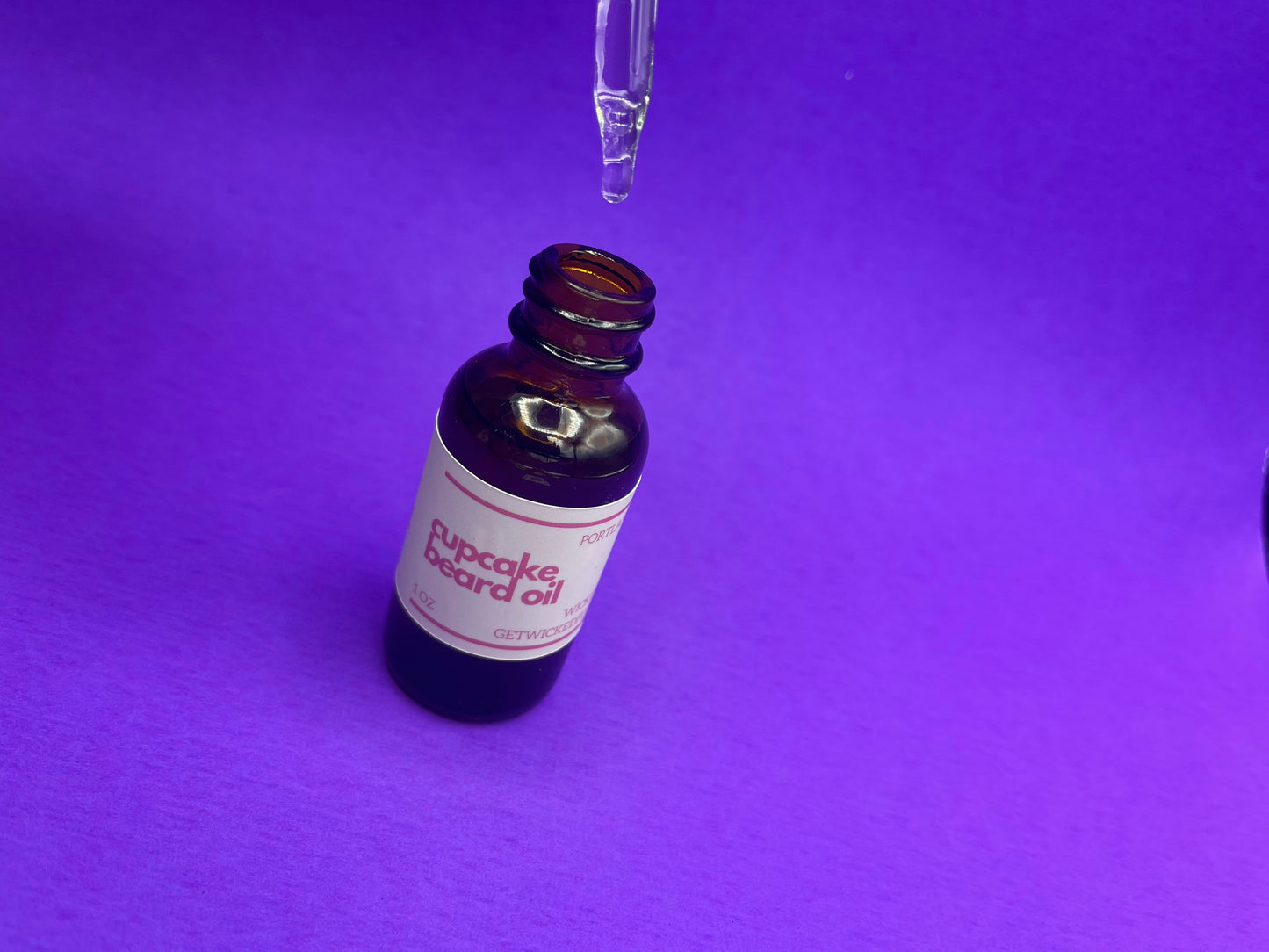 A bottle of Wicked Fox's Cupcake Beard Oil, enriched with natural ingredients, designed for the grooming needs of queer and trans men. Perfect for softening facial hair and reducing skin blemishes. Ideal beard care product for gay men shopping online.