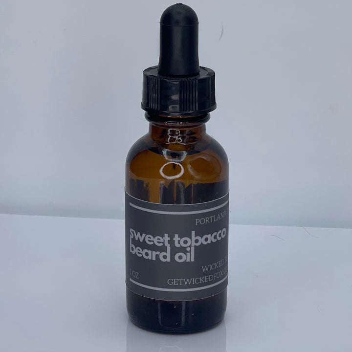 Wicked Fox's Sweet Tobacco Beard Oil, a premium beard care product targeted at gay men. This luxurious oil is infused with a sweet, masculine scent, designed to soften facial hair and prevent ingrown hairs. Making you more kissable, this must-have grooming accessory is perfect for those seeking a softer, more manageable beard.