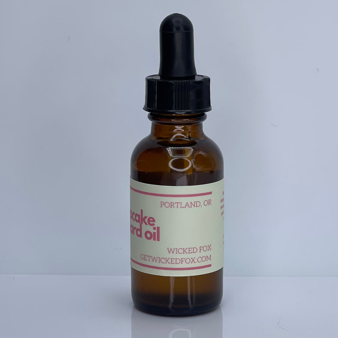A bottle of Wicked Fox's Cupcake Beard Oil, enriched with natural ingredients, designed for the grooming needs of queer and trans men. Perfect for softening facial hair and reducing skin blemishes. Ideal beard care product for gay men shopping online.