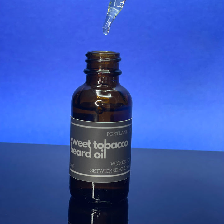 Wicked Fox's Sweet Tobacco Beard Oil, a premium beard care product targeted at gay men. This luxurious oil is infused with a sweet, masculine scent, designed to soften facial hair and prevent ingrown hairs. Making you more kissable, this must-have grooming accessory is perfect for those seeking a softer, more manageable beard.